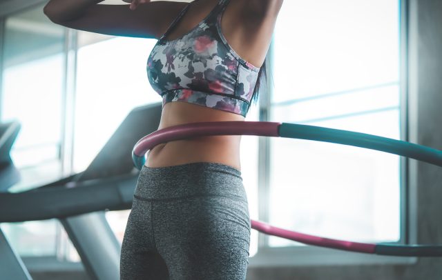 Fitness woman with shaker in gym, drinking water. Athletic girl, shaped  abdominal, slim waist Stock Photo