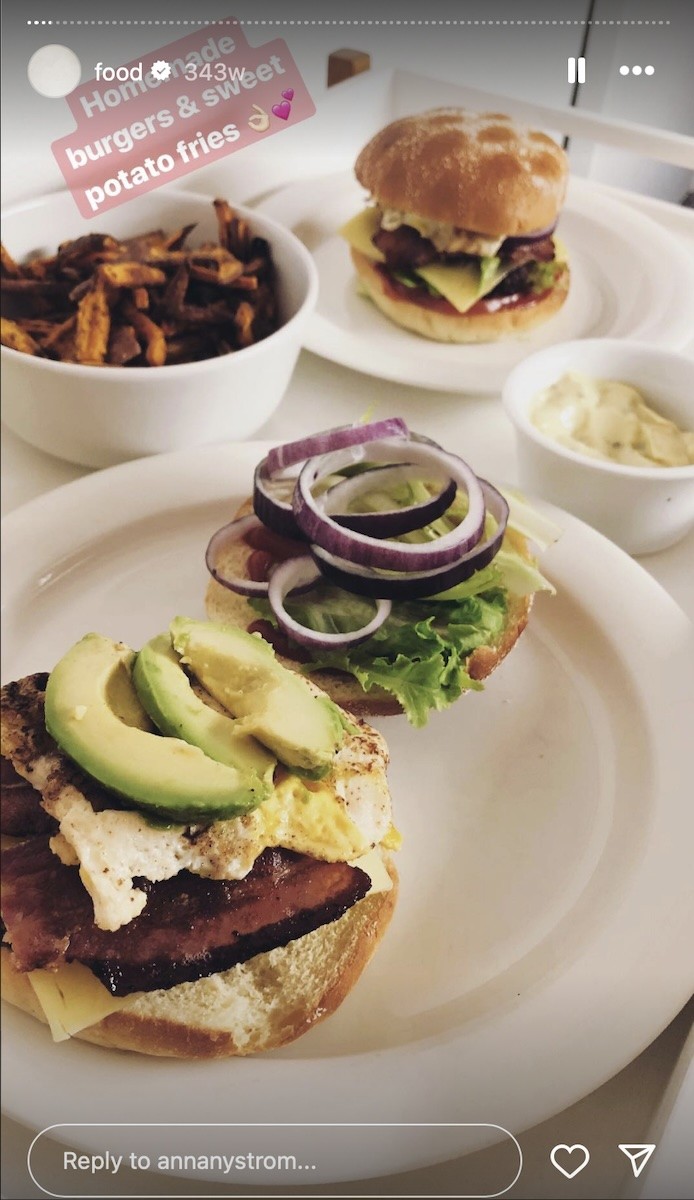 A cheeseburger with avocado, sweet potato fries