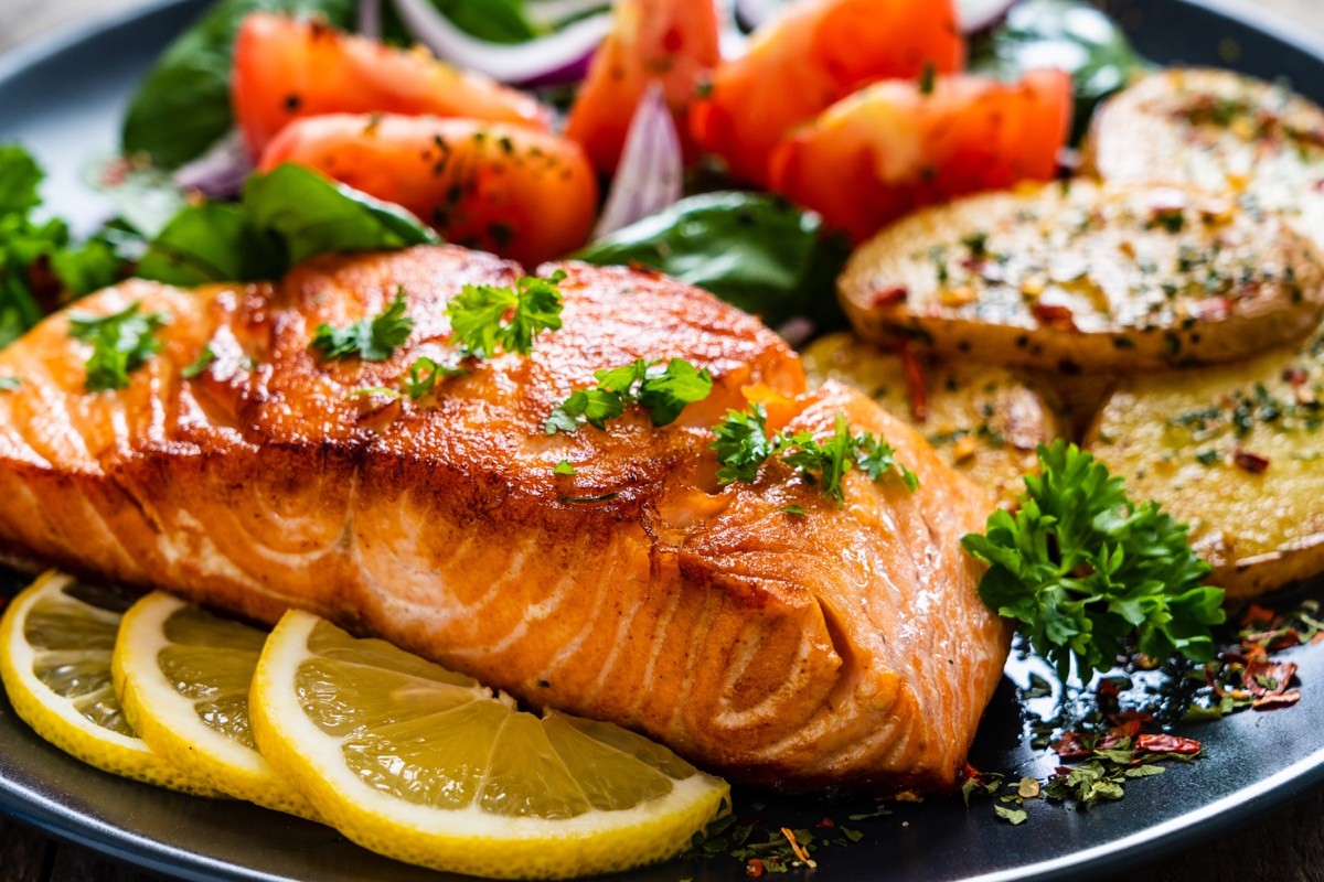 Fried,Salmon,Steak,With,Potatoes,And,Vegetables,On,Wooden,Table