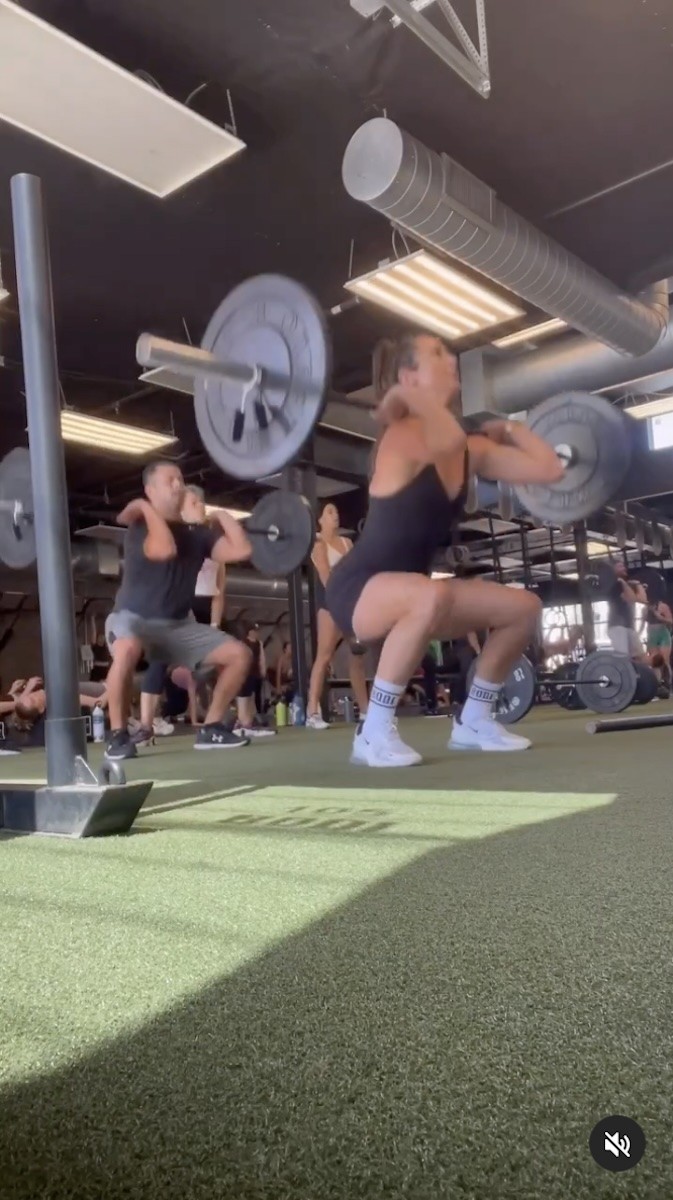 Nikki Metzger is seen doing a weighted squat at the gym.