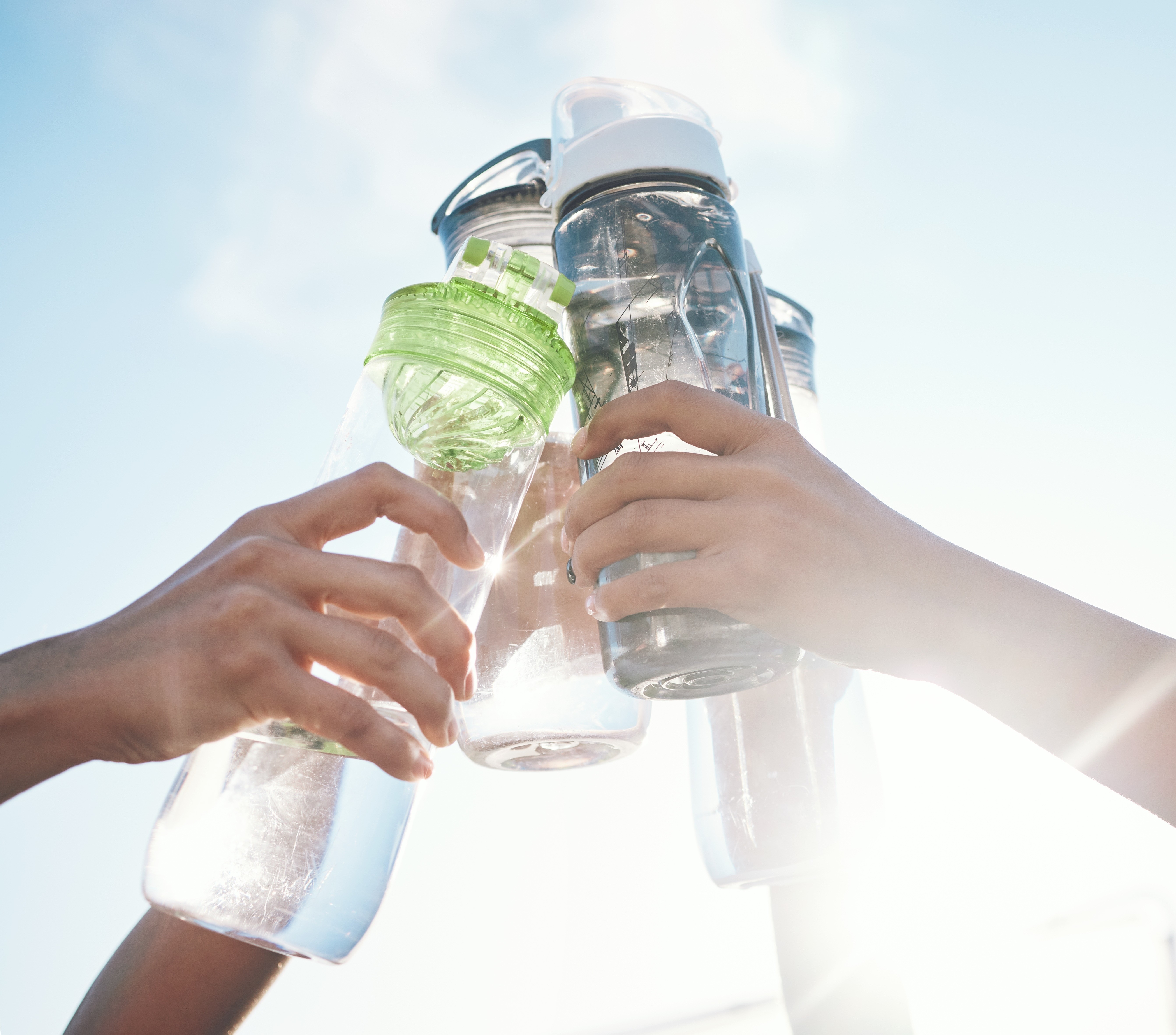 Friends doing a cheers with their water bottle