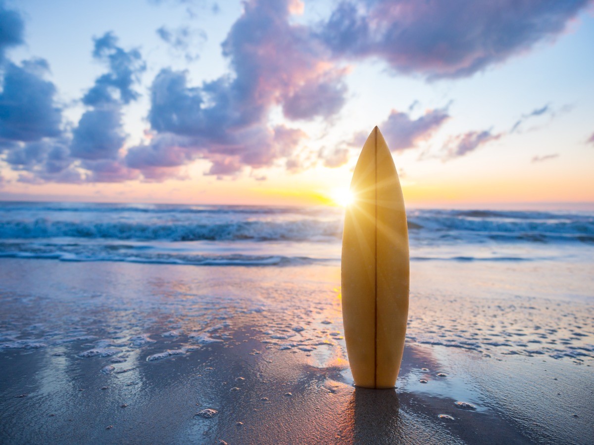 Surf,Surfboard,On,The,Beach,At,Sunset