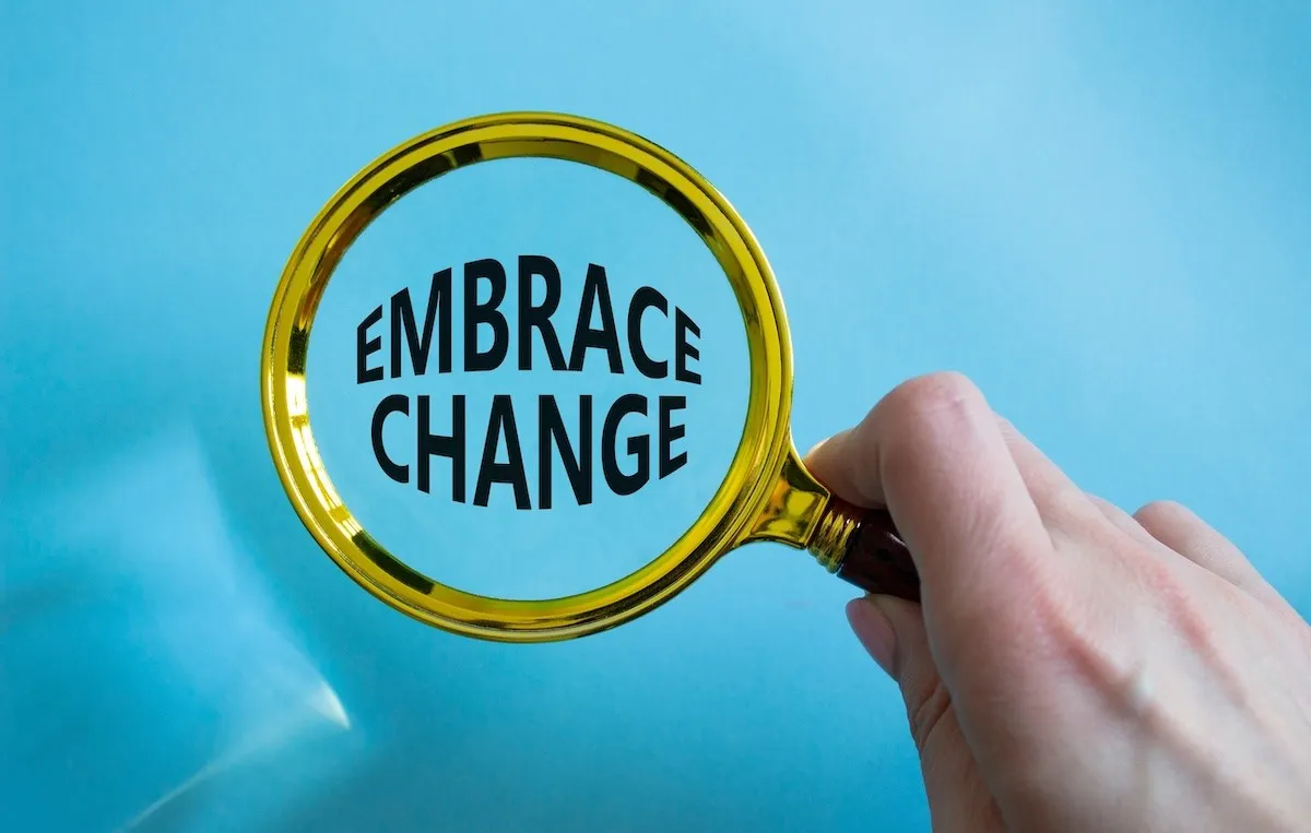 Gold magnifying glass over the words, "Embrace Change."