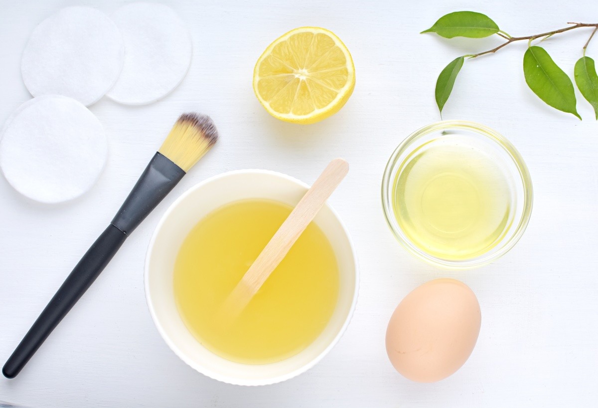 Egg, egg whites, lemon, and facial brush for a homemade face mask.