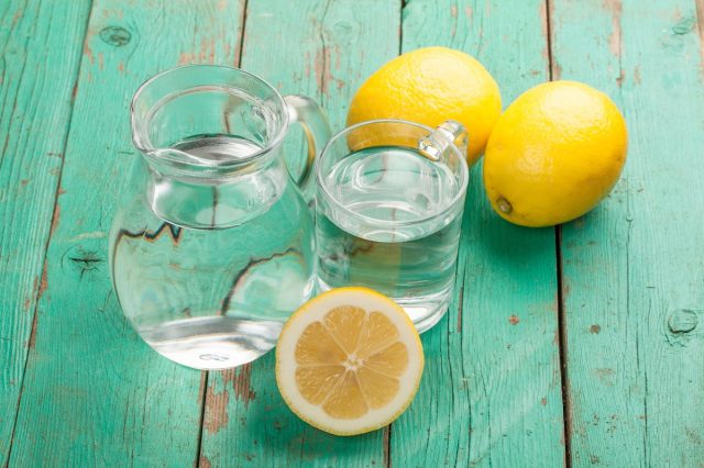 Glass,With,Water,And,Lemon,On,Wooden,Table