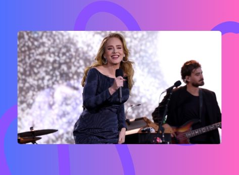Adele performing onstage in blue off-the-shoulder gown