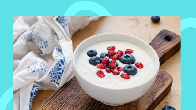 bowl of yogurt with berries on a cutting board